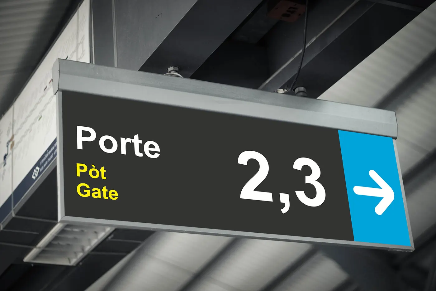 Panneau suspendu « Porte, Pòt, Gate 2, 3 » avec une flèche blanche sur fond bleu.
