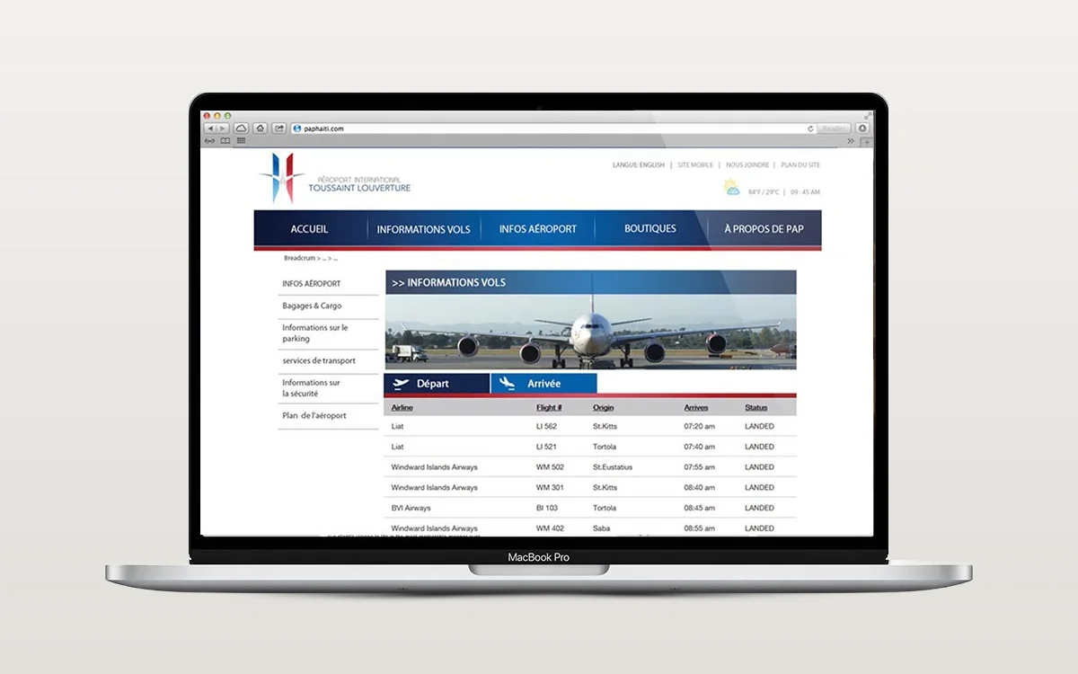 L’ancien site de l’aéroport PAP sur un portable : la page d’information des vols avec le tableau des arrivées sous un menu marine et rouge.